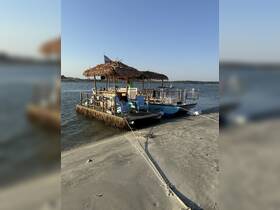 A charming tiki boat docked on a sandy shore, perfect for relaxing and enjoying the scenic waterfront views.