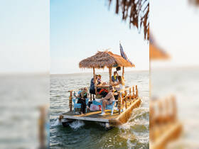 A lively group enjoys a fun day on a tiki boat, celebrating with drinks and laughter on the water — perfect for memorable outings with friends.