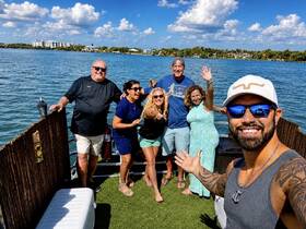 A cheerful group of friends poses for a selfie on a pontoon boat, enjoying a sunny day on the water — perfect for celebrations and memorable outings.