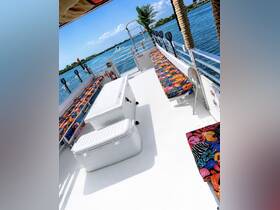 Interior view of a spacious boat cabin featuring colorful seating and a cooler, perfect for comfortable outings on the water.