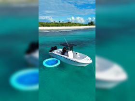 A stunning aerial view of a speedboat anchored in crystal-clear turquoise waters, showcasing the perfect setting for a day of relaxation and adventure on the water.
