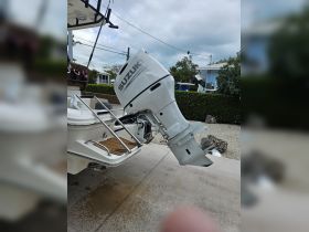 Close-up of a Suzuki outboard engine mounted on a boat, showcasing essential onboard equipment for smooth sailing.