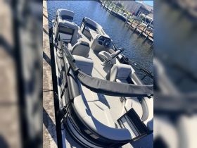An interior view of a stylish pontoon boat showcasing comfortable seating and a well-equipped helm, perfect for leisurely outings on the water.