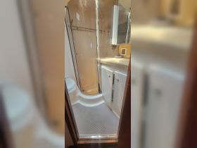A clean and modern bathroom inside a boat, featuring a shower and toilet, perfect for comfort during your nautical adventures.