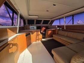 Interior view of a spacious boat cabin featuring comfortable seating and a well-equipped helm area, perfect for relaxing or navigating on the water.