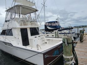 A detailed view of a yacht named 'My Favorite' docked at the marina, showcasing its sleek design and spacious upper deck.