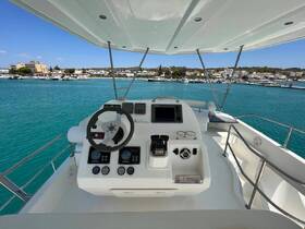 A clean and modern helm area of a boat, showcasing the console and steering wheel, perfect for navigating the beautiful turquoise waters.