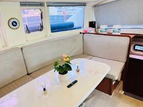 A cozy interior view of a boat's lounge area featuring comfortable seating and decorative plants, perfect for relaxation while on the water.