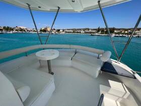 A spacious and inviting seating area inside a boat, perfect for relaxing while enjoying views of the marina and turquoise waters.