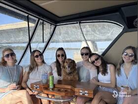 A cheerful group of friends enjoys a day on the boat, complete with a golden retriever, showcasing the perfect setting for celebrations and fun on the water.