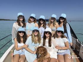 A cheerful group of friends poses on a boat, enjoying a sunny day on the water — perfect for celebrations and memorable outings.