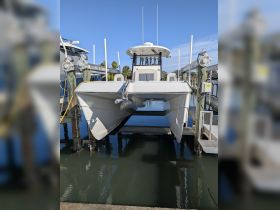 A sleek catamaran docked at the marina, showcasing its modern design and structure against a clear blue sky.