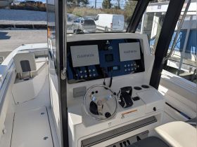 A detailed view of the helm and console area inside a boat, showcasing the Garmin navigation system and controls, perfect for navigating the open waters.
