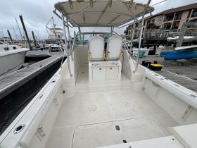 An interior view of a boat's helm and cabin area, showcasing the seating and console, perfect for navigation and comfort while on the water.