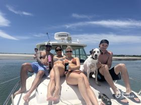 A fun group enjoys a sunny day on a boat, relaxing with drinks and a dog, perfect for memorable outings on the water.