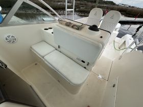 Interior view of a boat's helm and seating area, showcasing comfortable seating and a well-designed layout for a relaxing day on the water.