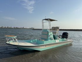 A vibrant side view of a fishing boat docked in calm waters, showcasing its sleek design and features — perfect for fishing trips or leisurely outings.