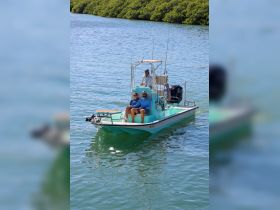 A cheerful group enjoys a day on the water aboard a fishing boat, perfect for creating unforgettable memories while exploring the beautiful coastline.