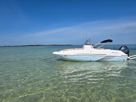 A sleek Hurricane speedboat anchored in clear waters, showcasing its elegant design against a picturesque backdrop.