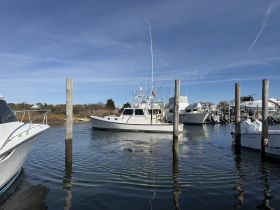 A serene view of fishing boats docked at a marina, showcasing the peaceful atmosphere of coastal life.