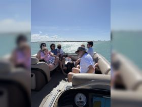 A joyful family gathers on a boat, enjoying a sunny day on the water — perfect for creating lasting memories and fun adventures.