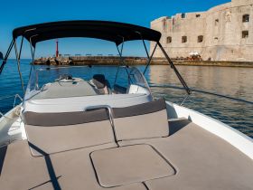 A serene view of the interior seating area on a boat, showcasing a comfortable helm and inviting space for relaxation while enjoying the calm waters.