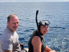 A couple prepares for an exciting snorkeling adventure in the open ocean, showcasing the thrill of water activities and marine exploration.