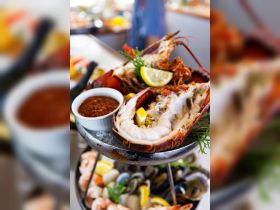 A beautifully presented seafood platter featuring fresh lobster with lemon and cocktail sauce, perfect for gourmet dining experiences on board.