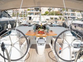 An inviting view of the helm area inside a yacht, featuring a beautifully arranged table with strawberries and drinks, perfect for a relaxing day on the water.