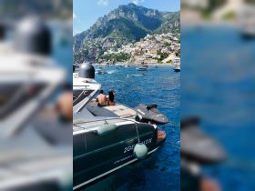 A couple enjoys the stunning views of the Amalfi Coast from their boat, capturing the essence of a perfect day on the water.