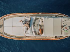 A couple relaxes on the deck of a luxurious yacht, enjoying the sun and the serene blue waters — an ideal setting for romantic getaways.