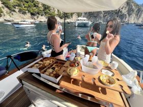 A lively group enjoys a day on the water, featuring delicious food and drinks while swimming in the beautiful surroundings — perfect for a fun-filled boat trip.