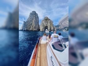 A group enjoys a scenic boat ride near stunning rock formations, capturing the beauty of the coastline and the joy of exploration on the water.