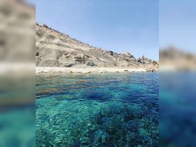 A stunning view of crystal-clear waters and a rugged coastline, perfect for showcasing the natural beauty of the destination.