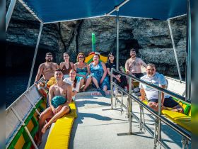 A cheerful group of friends enjoys a sunny day on a boat, capturing the essence of fun and adventure on the water.