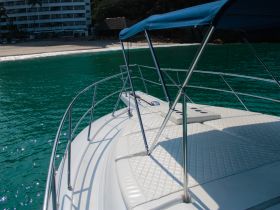 A stunning view of the front deck of a yacht, showcasing the sleek design and turquoise waters, perfect for a day of relaxation on the water.