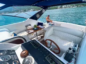 A stylish interior view of a boat's helm and seating area, featuring a guest relaxing on the deck — perfect for enjoying the scenic waterside.
