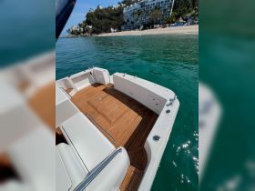A well-appointed interior view of a boat showcasing comfortable seating and polished wooden flooring, perfect for relaxing on the water.