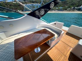 A beautifully designed interior space of a boat featuring comfortable seating and a polished table, perfect for relaxing while enjoying the view of the water.