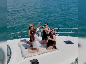 A group of friends celebrates on the deck of a yacht, raising cocktails against a stunning ocean backdrop — perfect for memorable gatherings and parties on the water.