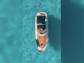 A stunning aerial view of a yacht cruising through crystal-clear turquoise waters, showcasing its sleek design and inviting deck space.