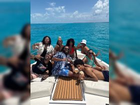 A lively group enjoys a fun day on the water, posing together on a boat under the bright sun — perfect for memorable celebrations and gatherings.