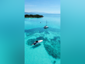 A stunning aerial view of two boats anchored in crystal-clear turquoise waters, surrounded by lush greenery — perfect for exploring serene coastal destinations.