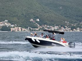 A lively group enjoys a thrilling ride on a speedboat, showcasing the excitement of on-water activities against a scenic backdrop.