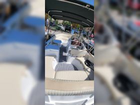 Interior view of a well-appointed boat cabin featuring comfortable seating and a helm, perfect for relaxing on the water.