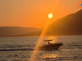 A boat navigates through shimmering waters at sunset, creating a picturesque scene perfect for evening cruises and relaxation on the water.