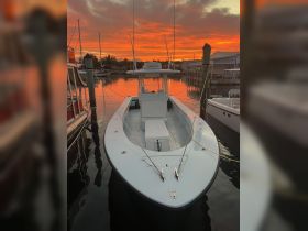 A stunning view of a boat docked at sunset, reflecting vibrant colors in the water — perfect for evening cruises or fishing trips.