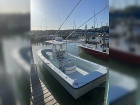 A pristine center console boat docked at the marina, showcasing its sleek design and ready for fishing adventures.
