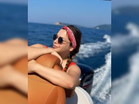 A woman enjoys a sunny day on the water, relaxing on a boat with a scenic backdrop — perfect for summer adventures and leisure outings.