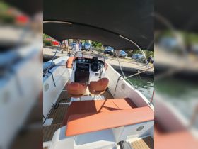 A well-appointed interior view of a boat's helm and seating area, showcasing comfortable seating and modern controls, ideal for a day on the water.